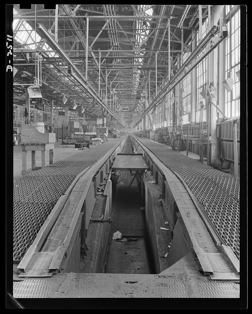 An empty factory assembly line stretching into the distance