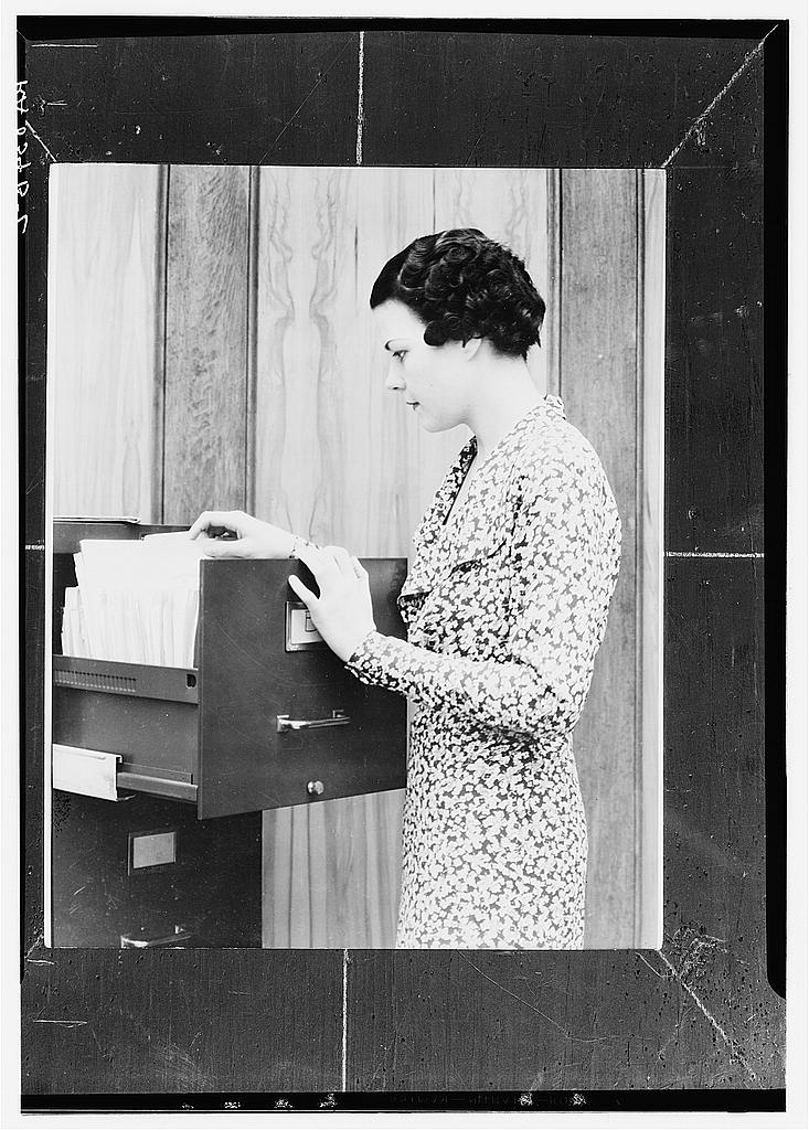 A woman worker at a filing cabinet in an office setting
